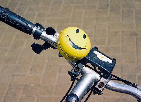 Smiley-Fahrradklingel an einem Fahrradlenker.